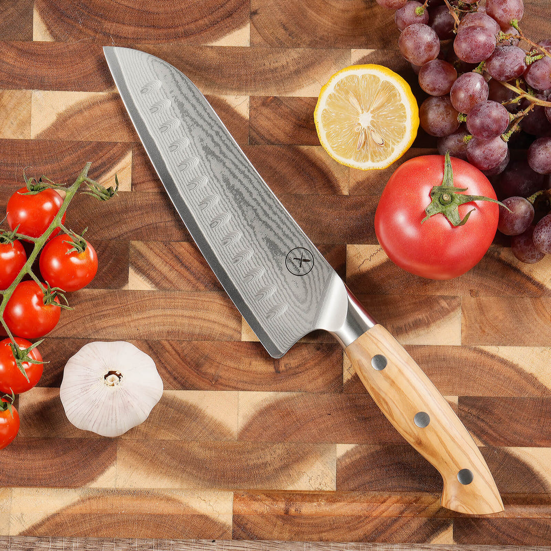 67-layer Damascus steel Santoku knife with olive wood handle on walnut cutting board